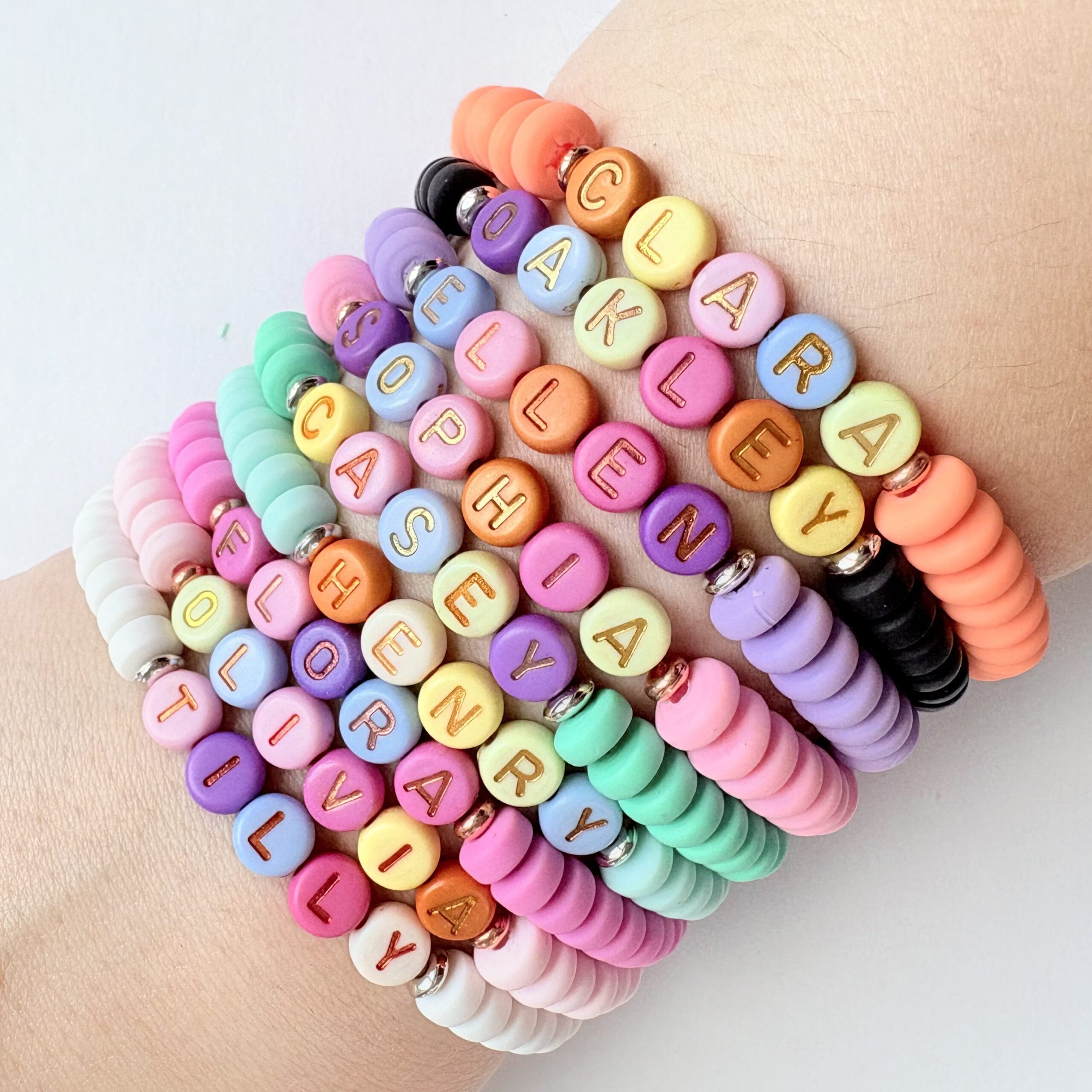 Sweet like Candy bracelets a stack of coloured personalised name bracelets on wrist